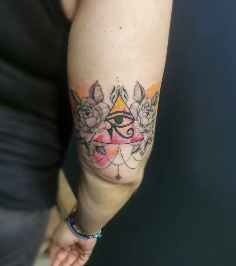 Tatouage psyché sur le coude et floral