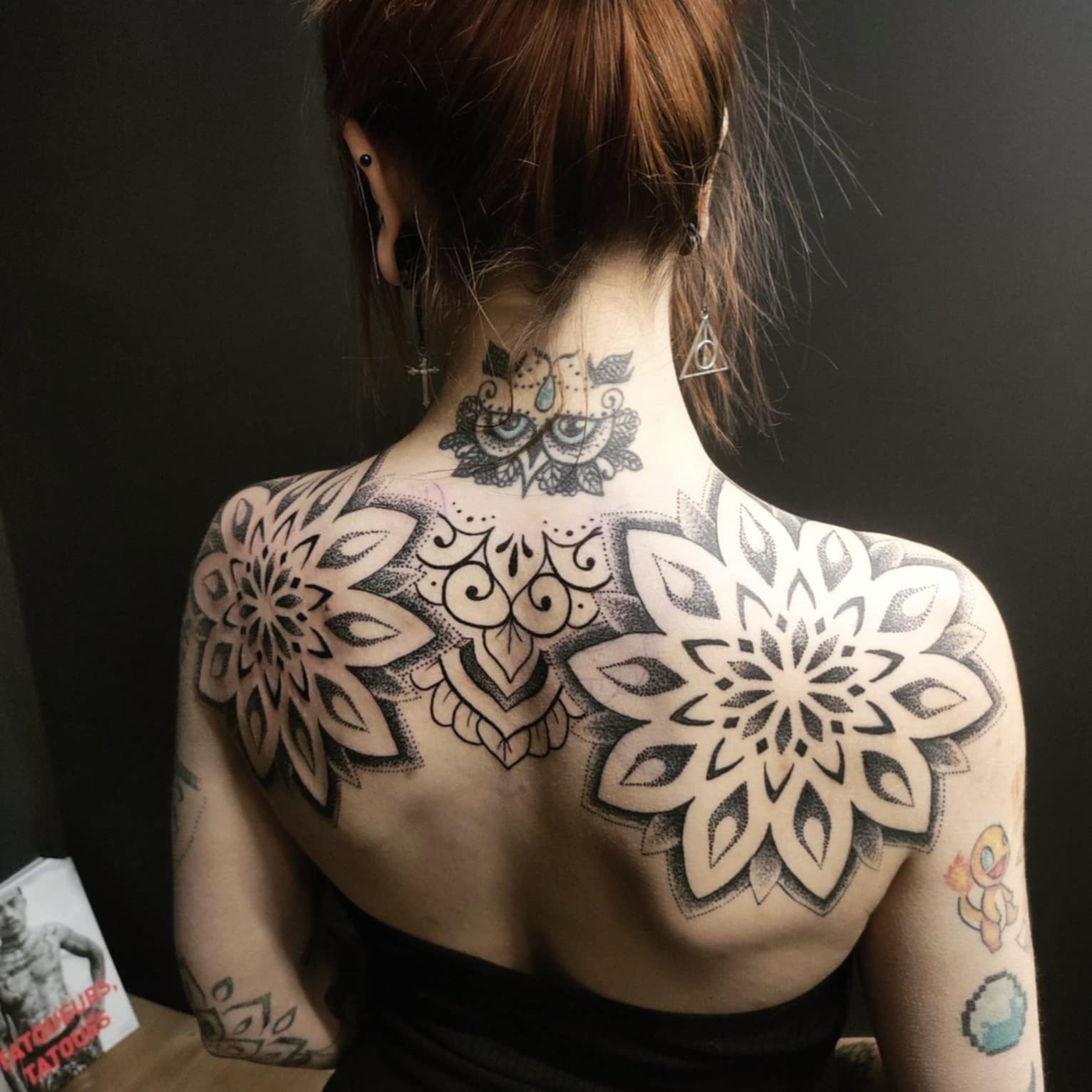 Photo d'un tatouage en haut du dos représentant hibou en dentelle sur la nuque ainsi que 2 gros mandalas en dotwork sur les épaules avec de l'ornemental en fatline pour relier les deux